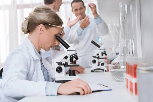 Cientista com microscópio em laboratório — Fotografia de Stock