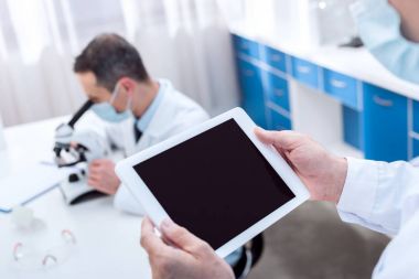 Scientist holding digital tablet clipart