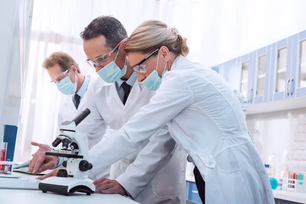 Scientists using microscope — Stock Photo, Image