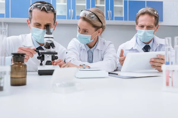 Doctors working with microscope — Stock Photo, Image