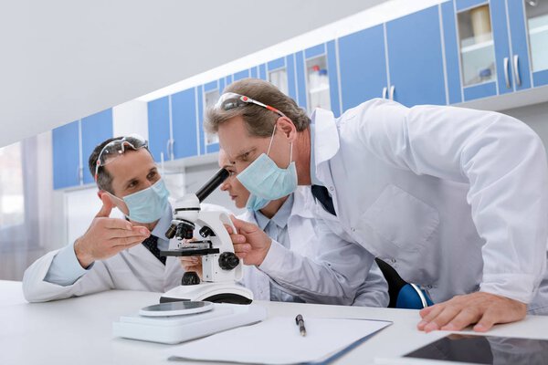 Scientists working with microscope
