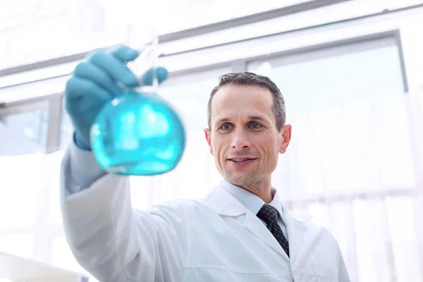 Cientista segurando frasco com reagente — Fotografia de Stock