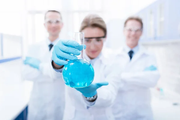 Doctor showing flask with reagent — Stock Photo, Image