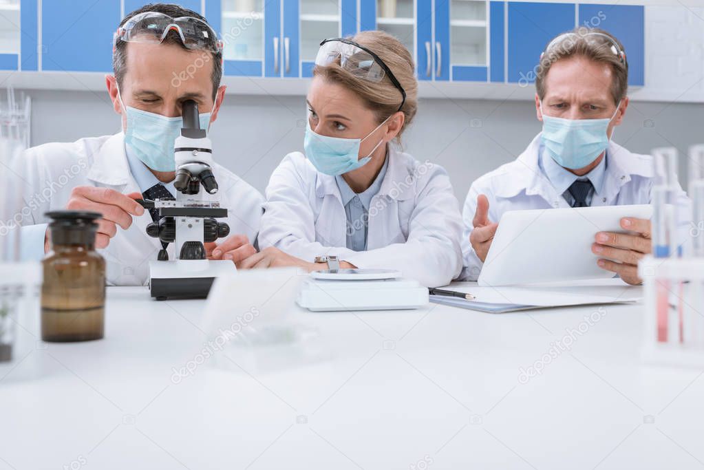 Doctors working with microscope