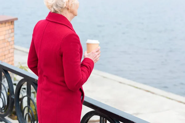 Senior woman with coffee on quay — Stock Photo, Image