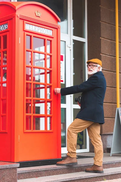 Homem idoso na cabine telefónica — Fotografia de Stock