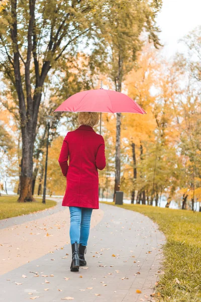 Женщина, гуляющая в осеннем парке — стоковое фото