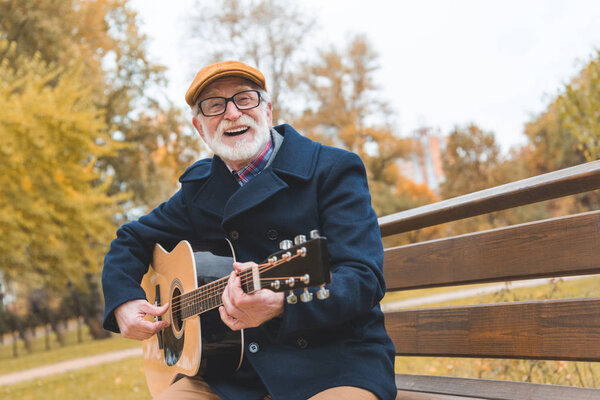 senior man playing on guitar