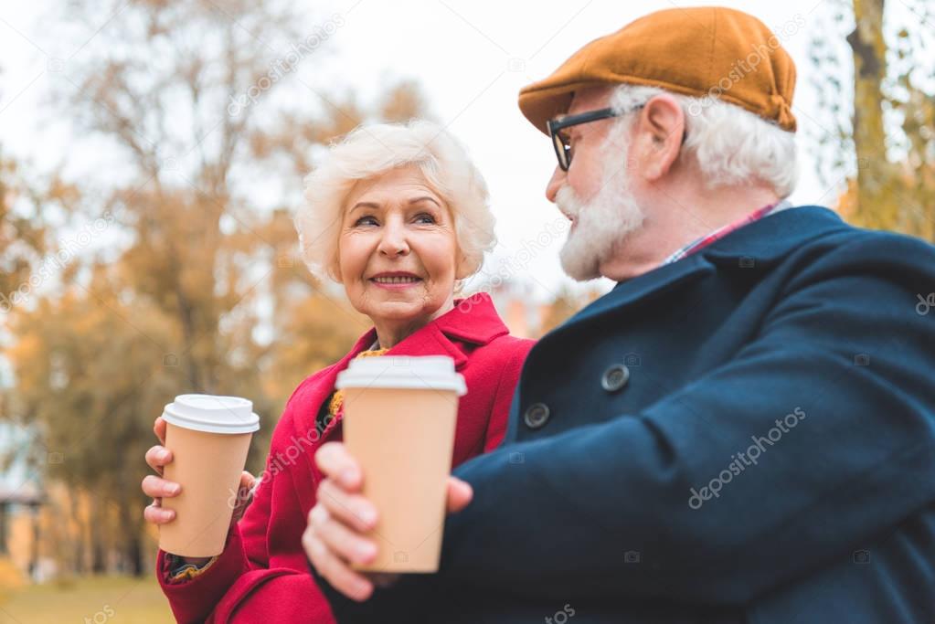 senior couple with coffee to go
