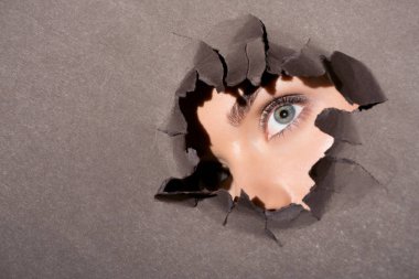 woman peeking out of hole in paper clipart
