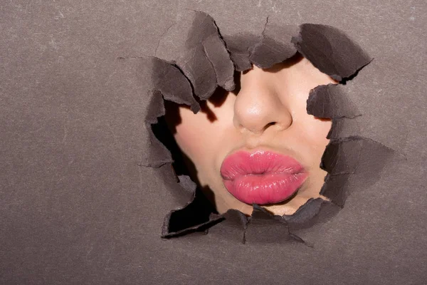 Rosa Lippen einer Frau im Papierloch — Stockfoto