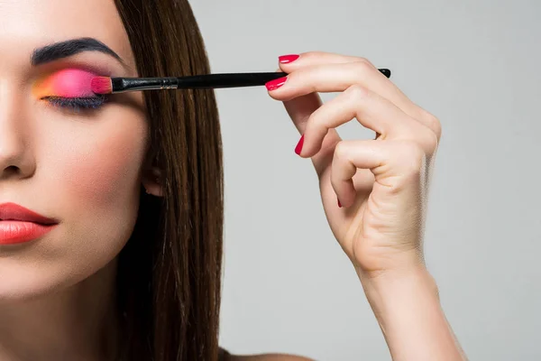 Vrouw toepassen van kleurrijke eyeshadows — Stockfoto