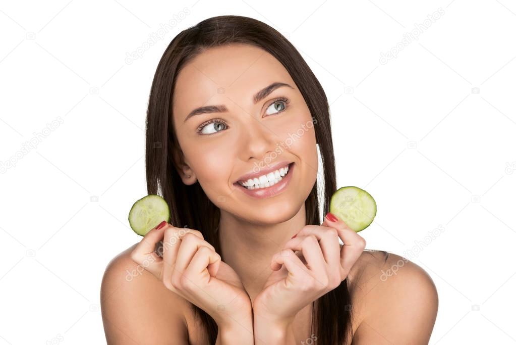 woman with slices of cucumber for skincare mask
