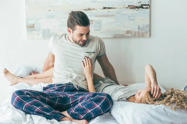Lyckliga unga paret på sängen — Stockfoto