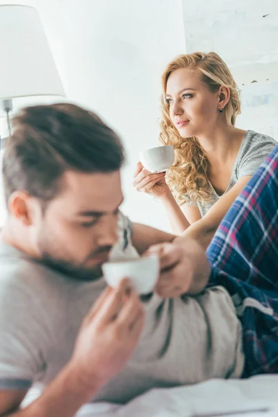 カップルはベッドの中でコーヒーを飲む — ストック写真