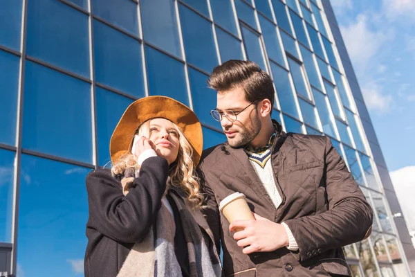 Couple with coffee to go and smartphone — Stock Photo, Image