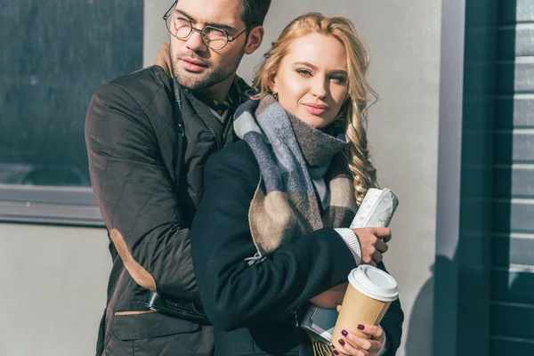 Couple with coffee to go and map — Free Stock Photo