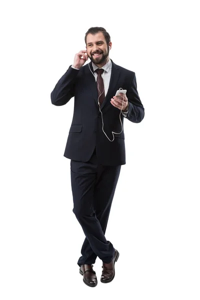 Smiling businessman listening music — Stock Photo, Image