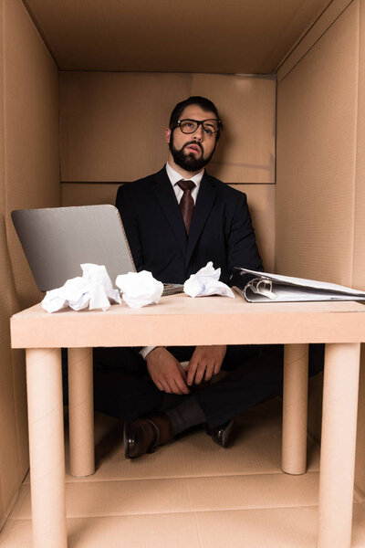 exhausted businessman sitting in box 