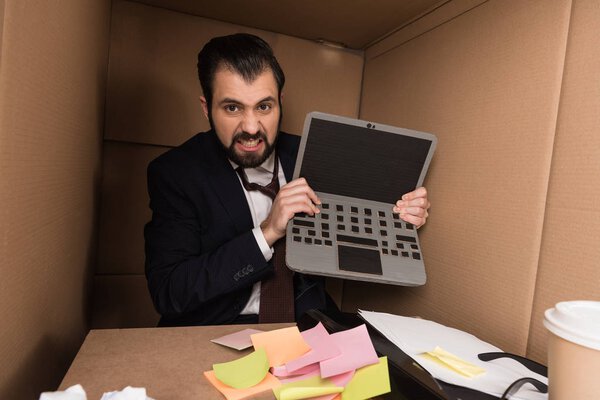 angry businessman with cardboard laptop
