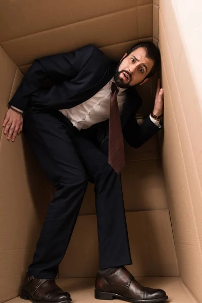 Empresário com claustrofobia dentro de uma caixa — Fotografia de Stock