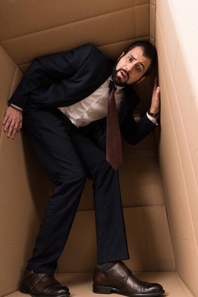 businessman with claustrophobia inside a box