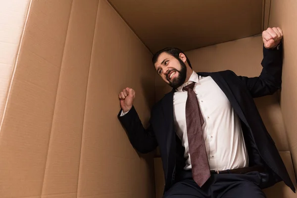 Напряженный бизнесмен в коробке — стоковое фото