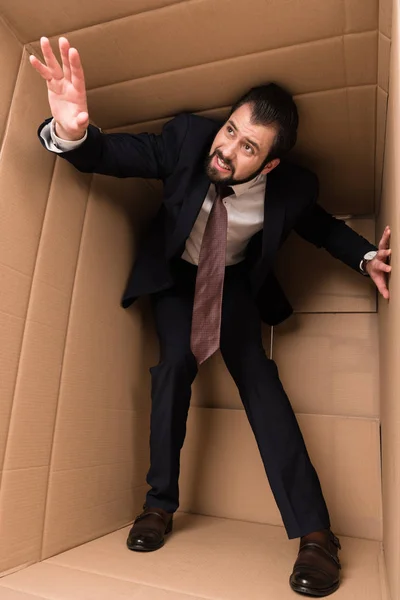 Stressed businessman standing in box — Stock Photo, Image