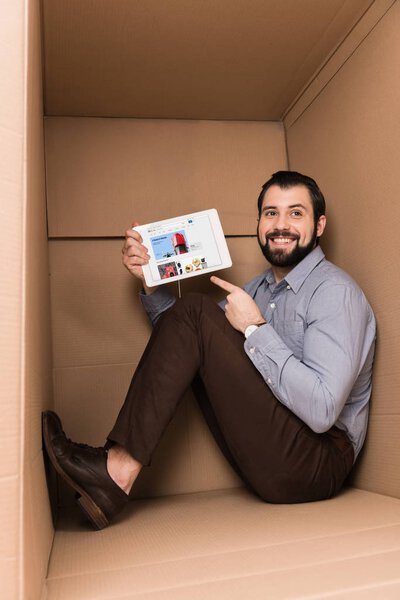 man pointing at tablet with ebay website 