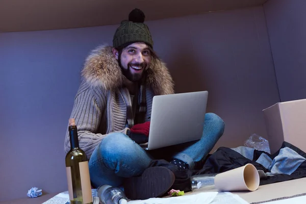 ノート パソコンでホームレスの男性 — ストック写真