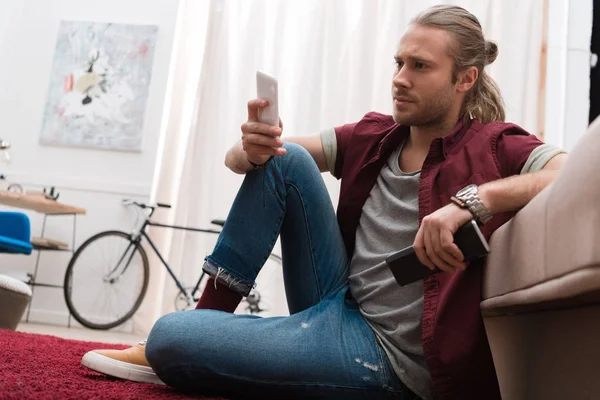 Hombre Guapo Con Control Remoto Teléfono Inteligente Casa — Foto de Stock