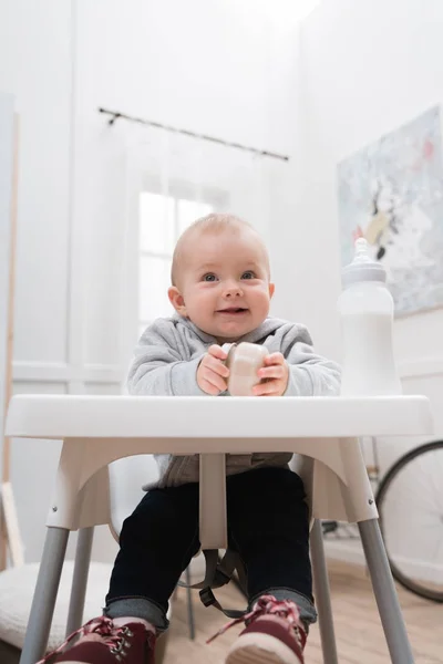 Adorable Smiling Child Sitting Baby Chair Kitchen Holding Baby Food — Stock Photo, Image