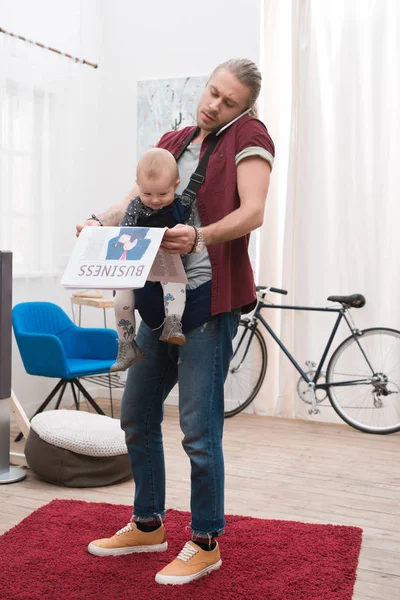 Pai Com Filho Funda Bebê Segurando Jornal Falando Por Smartphone — Fotografia de Stock