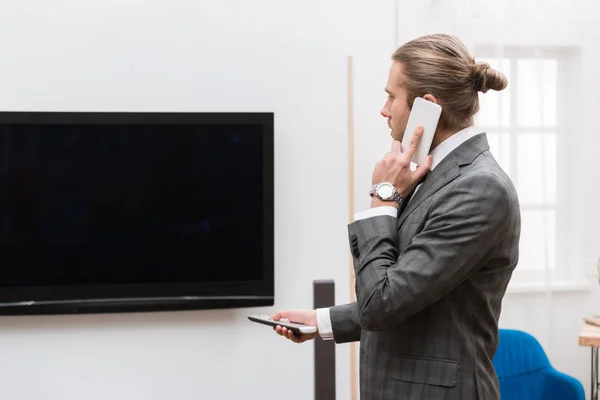 Empresario Hablando Por Teléfono Inteligente Encendiendo Televisión Casa — Foto de stock gratis