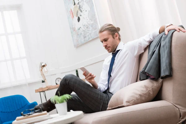 Hombre Negocios Serio Usando Teléfono Inteligente Mientras Está Sentado Sofá — Foto de Stock