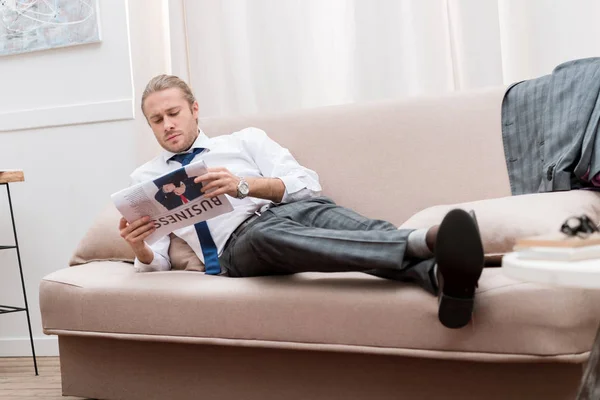 Empresário Confiante Ler Jornal Enquanto Descansa Sofá Casa — Fotografia de Stock