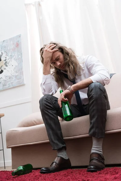 Homem Sentado Sofá Com Uma Cerveja Com Dor Cabeça — Fotografia de Stock Grátis