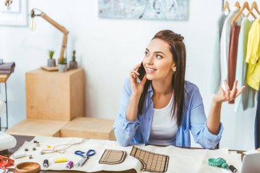gülümseyen Tasarımcısı yanında smartphone çalışma yerde konuşmak 