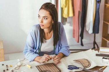 çalışma masada oturan ve uzağa bakarak düşünceli terzi