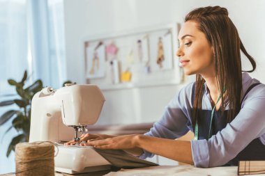 beautiful seamstress sewing with sewing machine  clipart