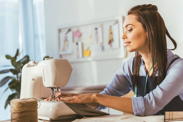 beautiful seamstress sewing with sewing machine 