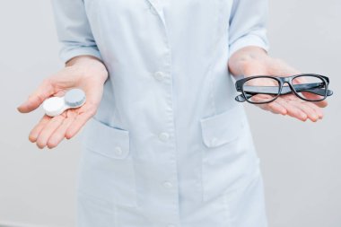 gözlük ve Kontakt lens, üzerinde beyaz izole holding beyaz paltolu optometrist kırpılmış görünümünü