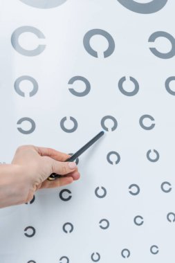 cropped view of oculist pointing at eye chart  clipart