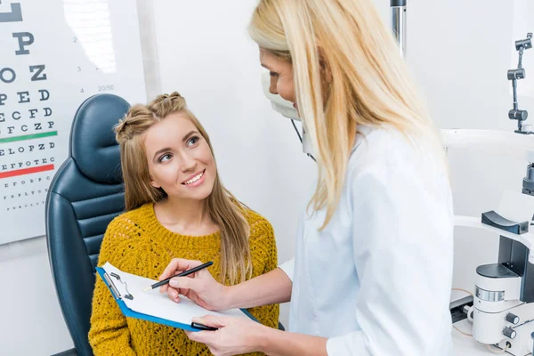 Optometrist Writing Diagnosis Smiling Patient Clinic — Stock Photo, Image