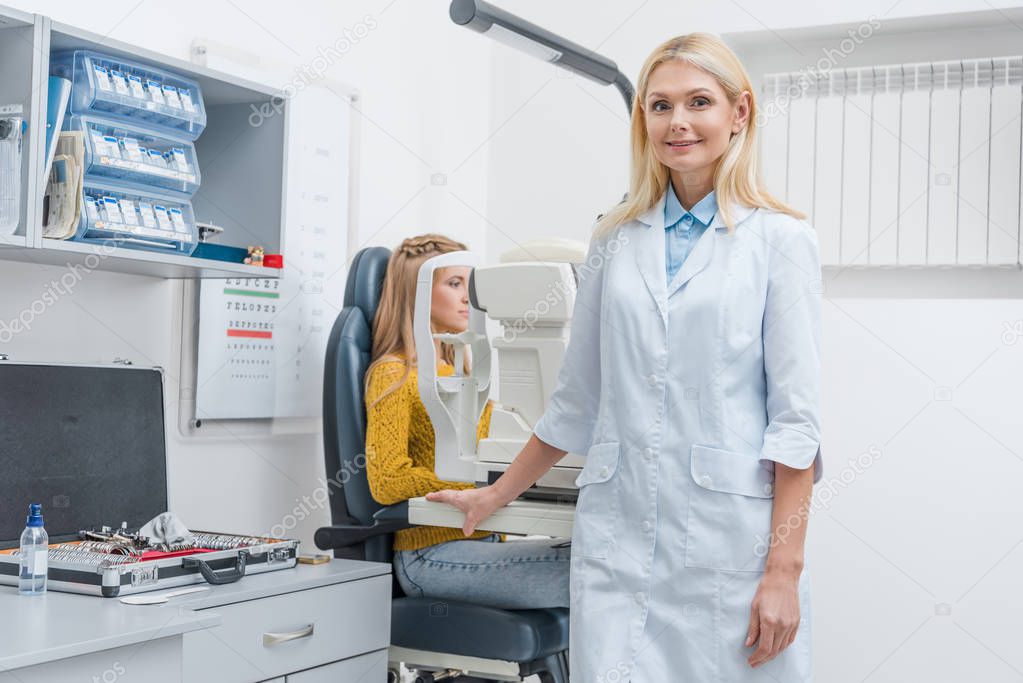 female optometrist examining patient through slit lamp in clinic