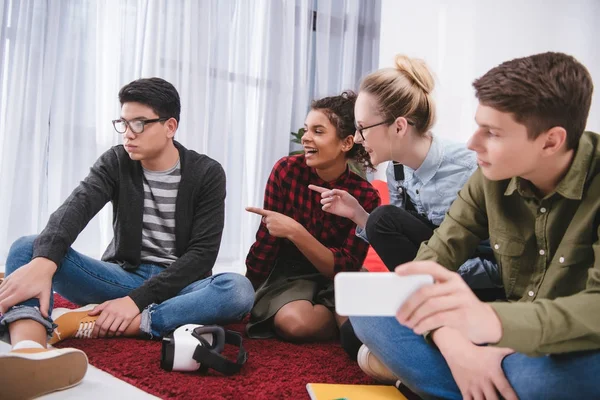 Jóvenes Adolescentes Riéndose Sentados Alfombra Estudiando Señalando Niño — Foto de stock gratis