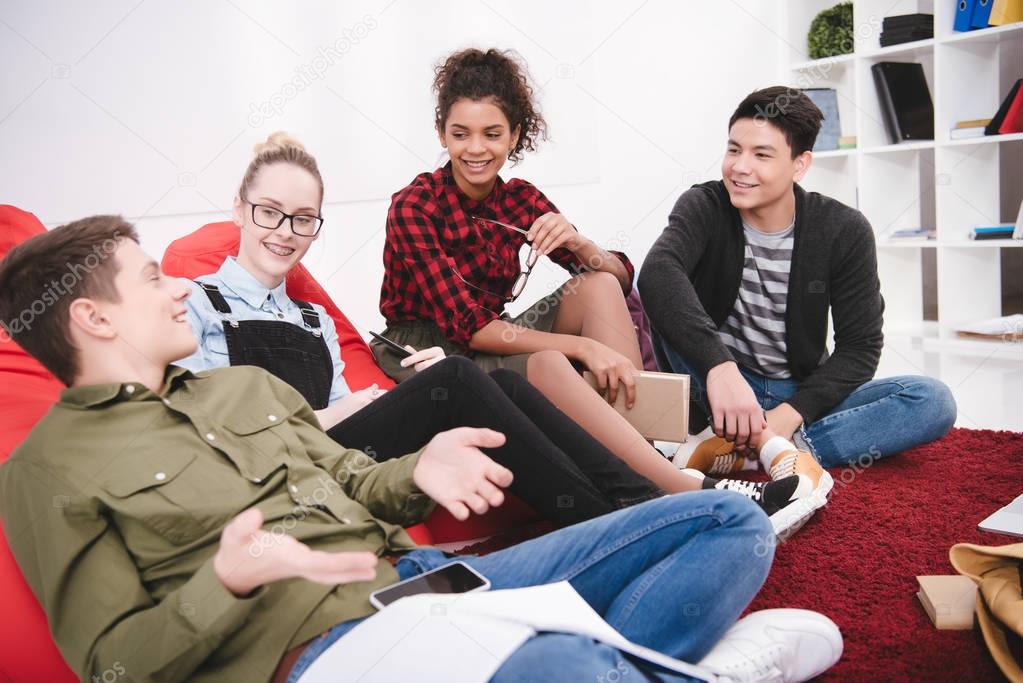 cheerful students sitting with exercise books