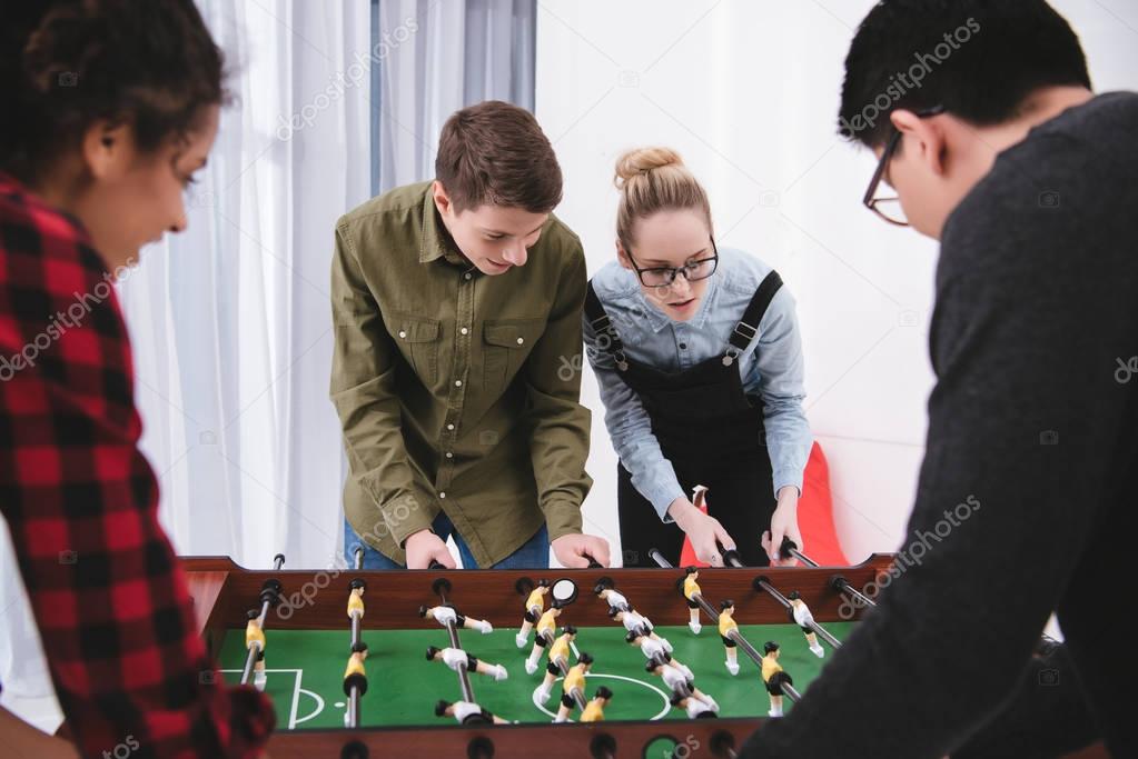happy cheerful teenagers playing in table soccer