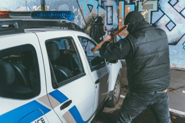 Vandal kilitlenen polis arabası beyzbol ile yarasa ise başka bir adam boyama grafiti duvar