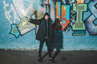 duman bombası basılı tutup duvara graffiti ile geceleri ayakta beyaz adam
